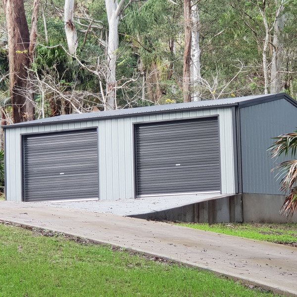 A double garage with a gable roof and gum trees in the background