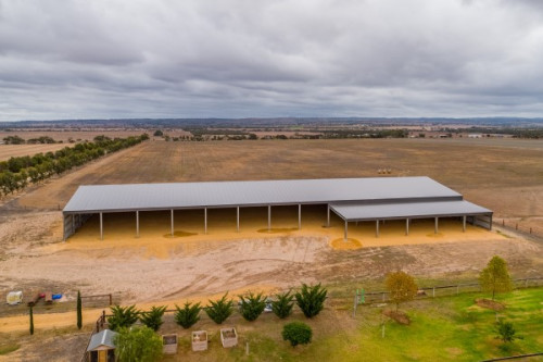 A large arena in a rural setting shot from the air showing a number of open bays