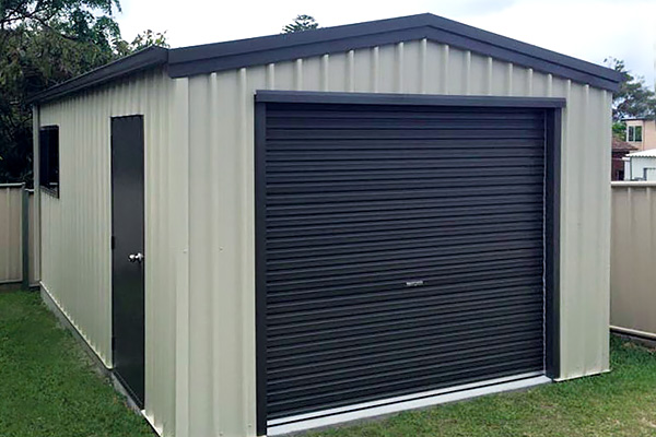 Single white garage with black doors and trim with roller door and side personal access door.