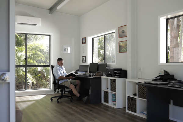 Man working in a home office built within a shed