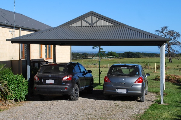 Two cars parked beneath dutch gable carport